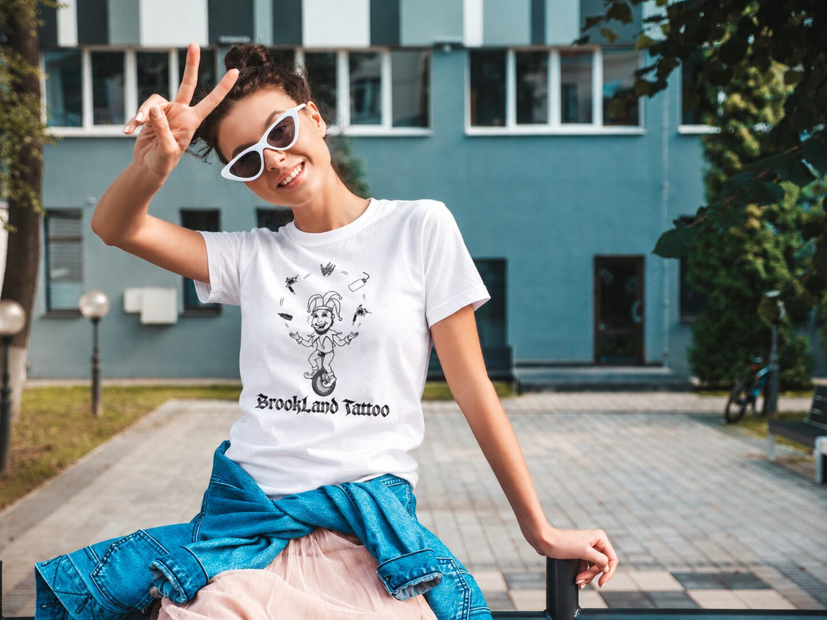 Smiling woman in sunglasses throwing a peace sign, wearing a Brookland Tattoo tee